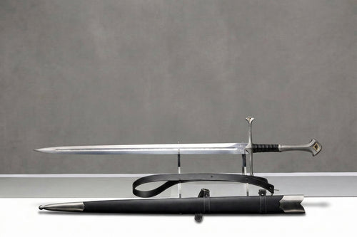 Andúril Sword - The Lord of the Rings: Silver sword with engraved blade, black grip, on clear stand, black leather scabbard, grey background
