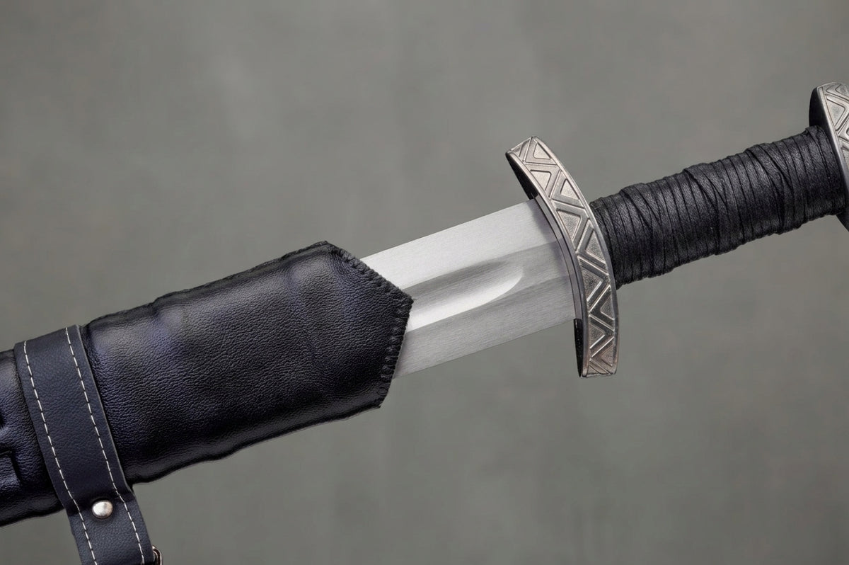 Blackfjord Viking Sword: Silver viking sword blade, patterned guard, black wrapped grip, black leather scabbard on grey