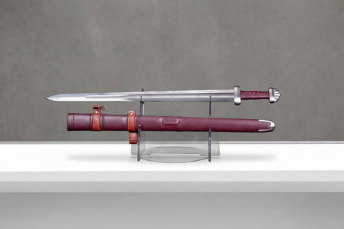 Bloodmoon Viking Sword: steel viking sword with red leather grip beside burgundy leather scabbard on grey concrete background