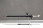 Halbrand's Sword - The Lord of the Rings: The Rings of Power: Black leather sword scabbard with silver chape and white-gripped sword on clear stand, grey background