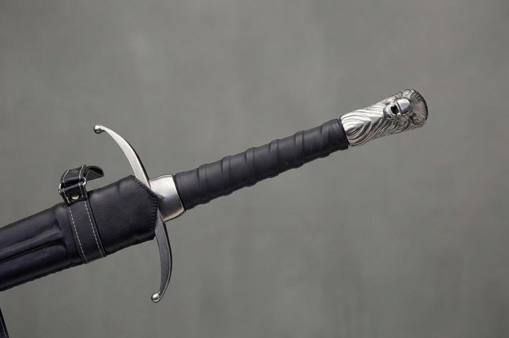 Longclaw - Jon Snow's Sword - Game of Thrones: Black leather-wrapped sword hilt with silver wolf-head pommel, partially sheathed in black leather scabbard on grey